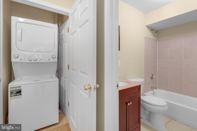 washroom featuring stacked washing maching and dryer and light tile patterned floors