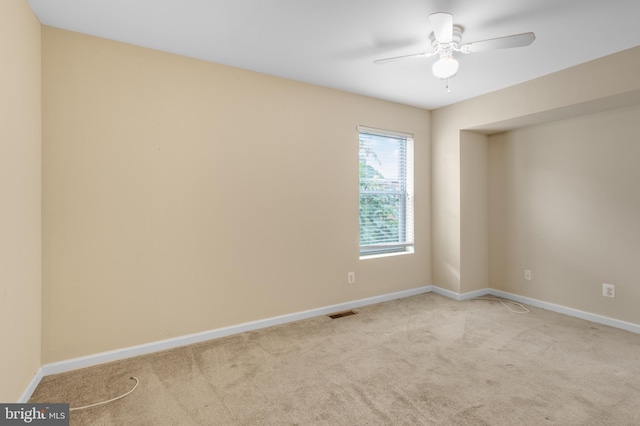 unfurnished room with light colored carpet and ceiling fan