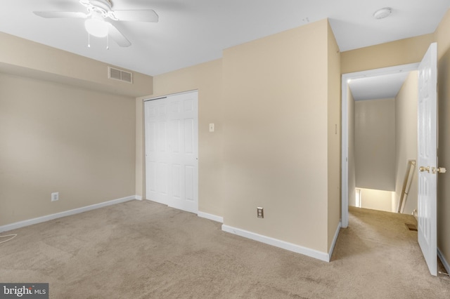 unfurnished bedroom featuring a closet, ceiling fan, and light carpet