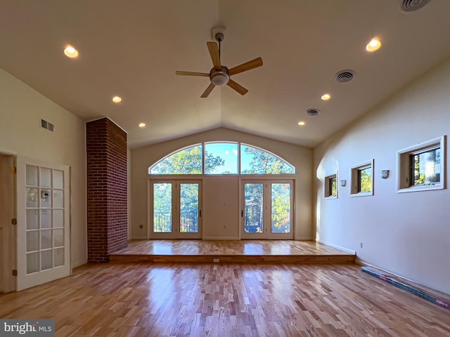 unfurnished living room featuring ceiling fan, light hardwood / wood-style flooring, french doors, and vaulted ceiling