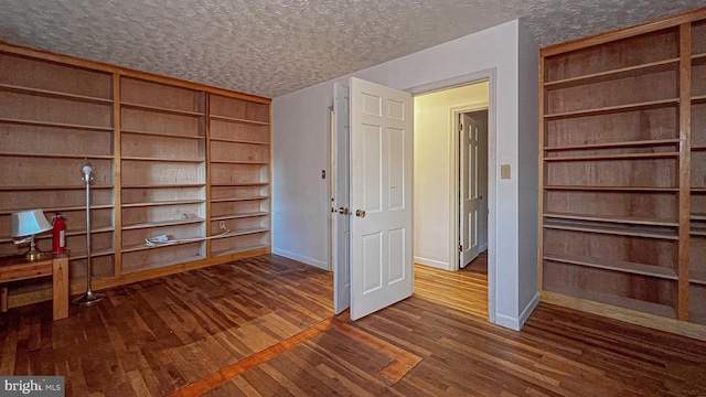 interior space featuring a textured ceiling and dark hardwood / wood-style floors