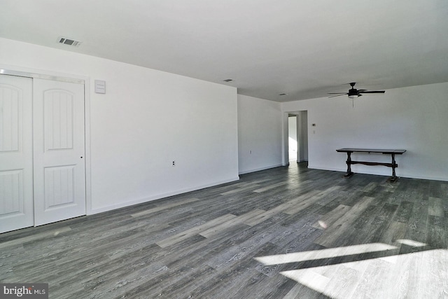 empty room with a ceiling fan, baseboards, visible vents, and wood finished floors