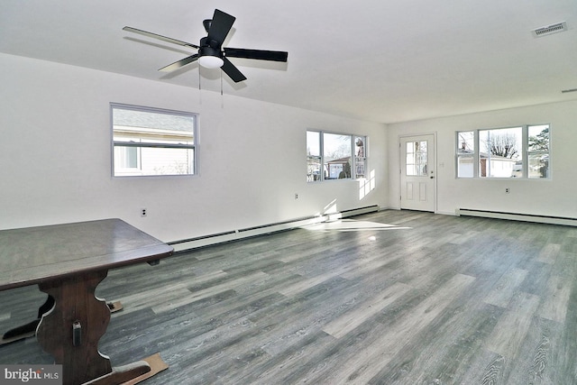 unfurnished living room with a ceiling fan, visible vents, a baseboard heating unit, and wood finished floors