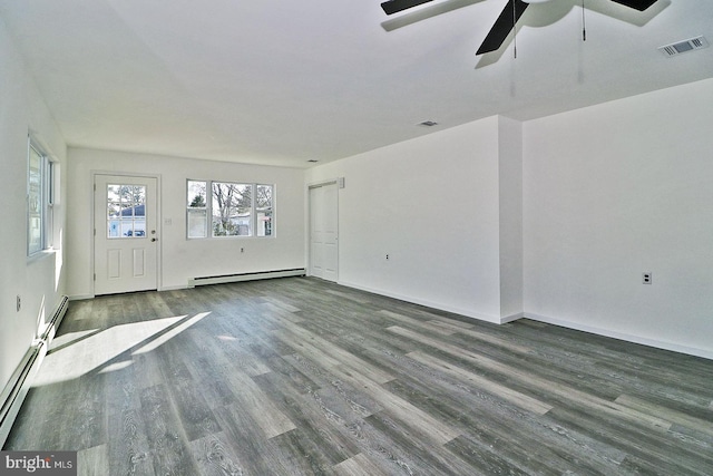 unfurnished room with a baseboard heating unit, baseboards, visible vents, and wood finished floors