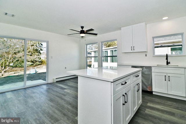 kitchen featuring a baseboard radiator, visible vents, dark wood-type flooring, a sink, and dishwasher