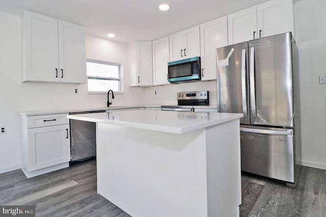 kitchen featuring a center island, dark wood-style flooring, appliances with stainless steel finishes, white cabinetry, and a sink