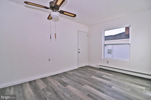 unfurnished room featuring a baseboard heating unit, ceiling fan, wood finished floors, and baseboards