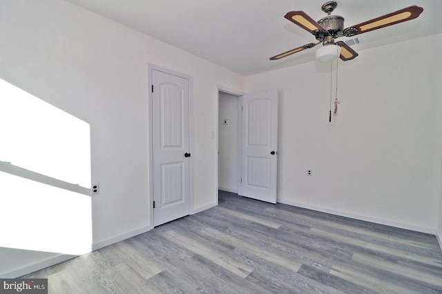 unfurnished room featuring a ceiling fan, baseboards, and wood finished floors