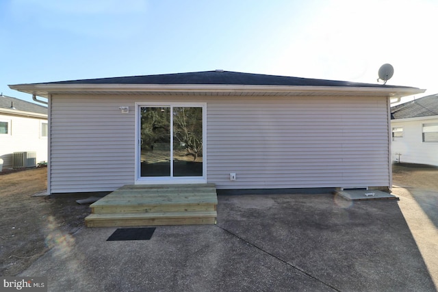 rear view of property featuring entry steps and central AC unit