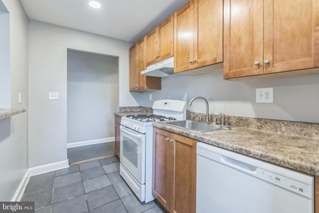 kitchen featuring sink, dark tile patterned floors, and white appliances