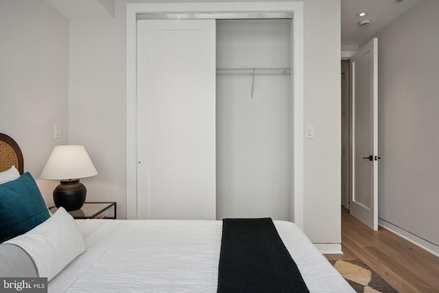 bedroom with light hardwood / wood-style flooring and a closet