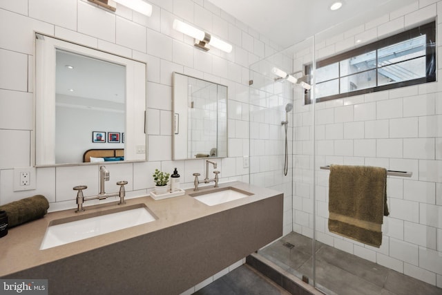 bathroom with vanity, a shower with shower door, and tile walls