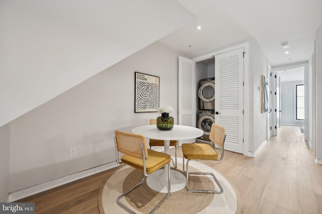 dining space featuring light hardwood / wood-style floors and stacked washing maching and dryer