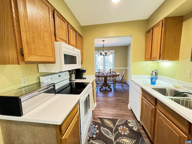 kitchen featuring pendant lighting, a notable chandelier, white appliances, and dark hardwood / wood-style flooring