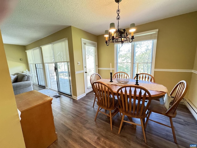 dining space with a textured ceiling, dark hardwood / wood-style floors, a chandelier, and a baseboard heating unit