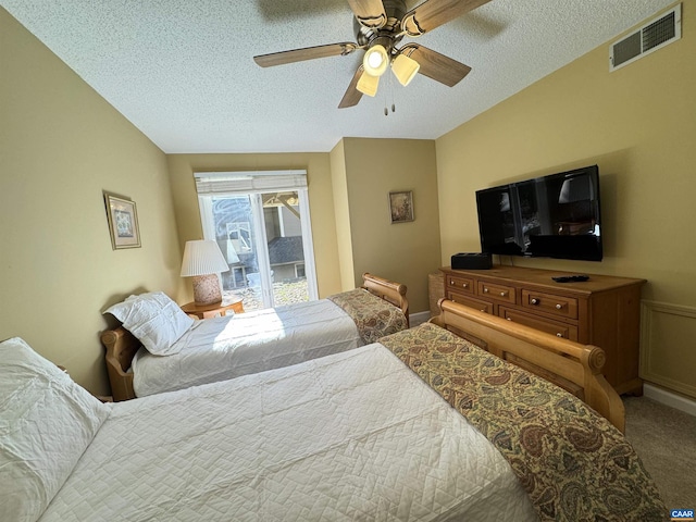 carpeted bedroom with ceiling fan, vaulted ceiling, and a textured ceiling