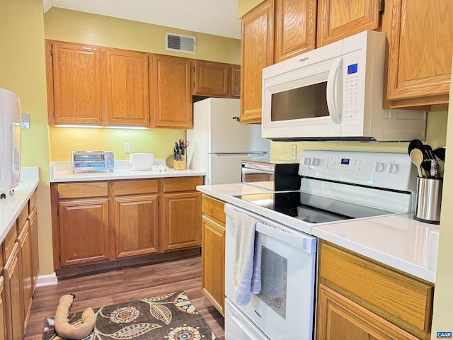 kitchen with dark hardwood / wood-style floors and white appliances