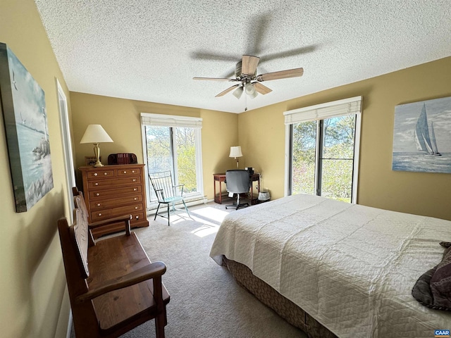 bedroom with ceiling fan, a textured ceiling, and carpet flooring