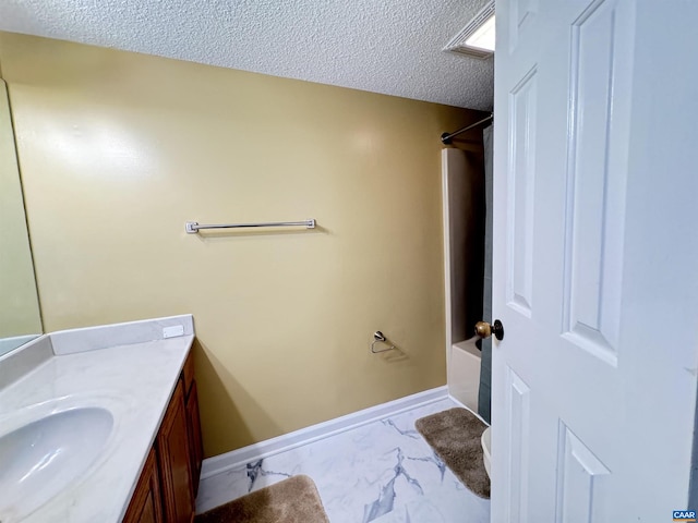 full bathroom featuring toilet, washtub / shower combination, vanity, and a textured ceiling