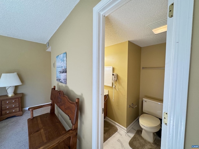 bathroom with vaulted ceiling, a textured ceiling, and toilet