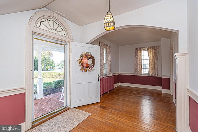 entrance foyer featuring a wealth of natural light, lofted ceiling, hardwood / wood-style floors, and radiator heating unit