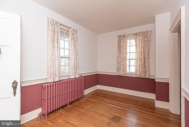 spare room with hardwood / wood-style flooring and radiator