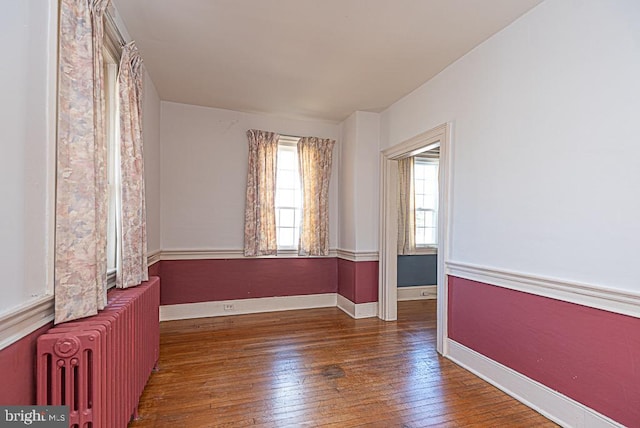 unfurnished room featuring dark wood-type flooring and radiator