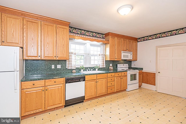 kitchen featuring decorative backsplash, sink, and white appliances