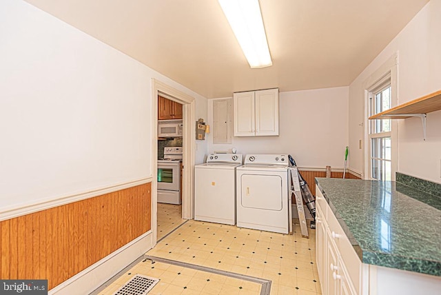 laundry room with wooden walls and washing machine and clothes dryer