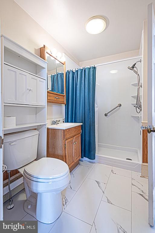 bathroom featuring vanity, curtained shower, and toilet