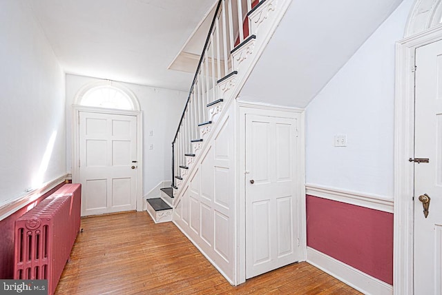 entryway with light wood-type flooring and radiator