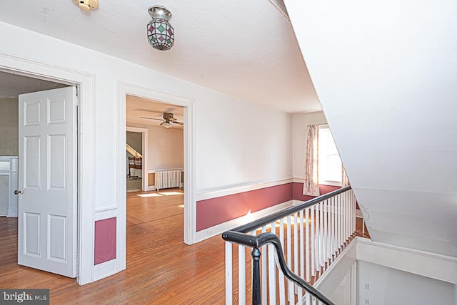 hall with radiator heating unit and hardwood / wood-style floors