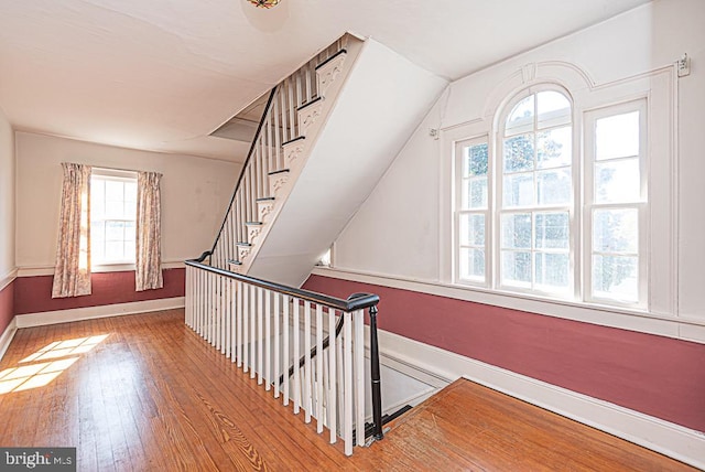 stairway featuring lofted ceiling and wood-type flooring