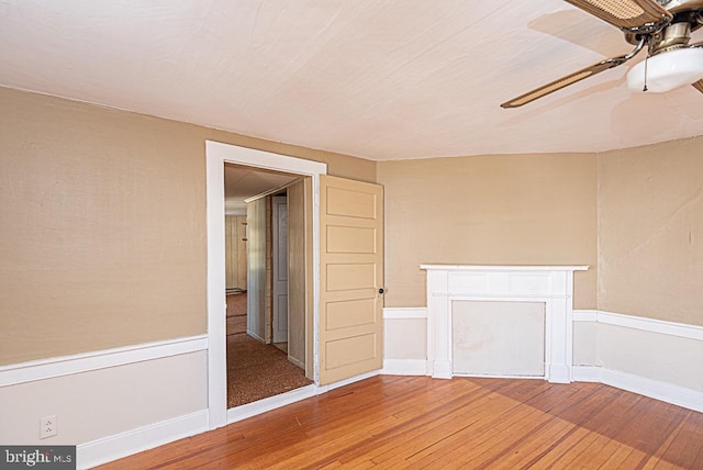 empty room with hardwood / wood-style floors and ceiling fan