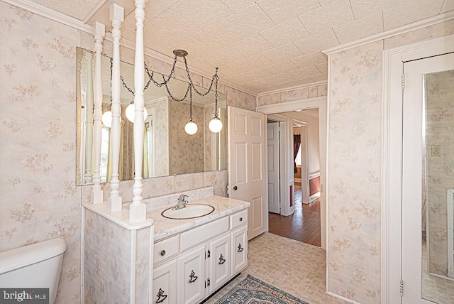 bathroom with vanity, crown molding, hardwood / wood-style flooring, and toilet