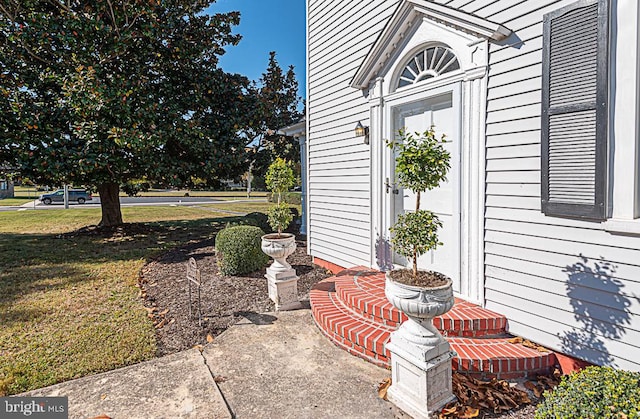 view of exterior entry with a yard