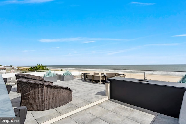 view of patio featuring a view of the beach and a water view