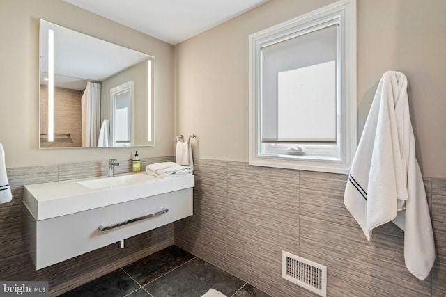 bathroom featuring tile patterned floors, vanity, and tile walls