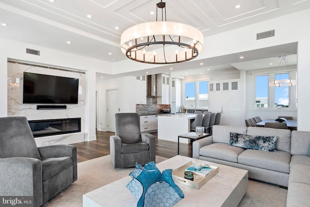 living room featuring light hardwood / wood-style floors, a fireplace, and an inviting chandelier