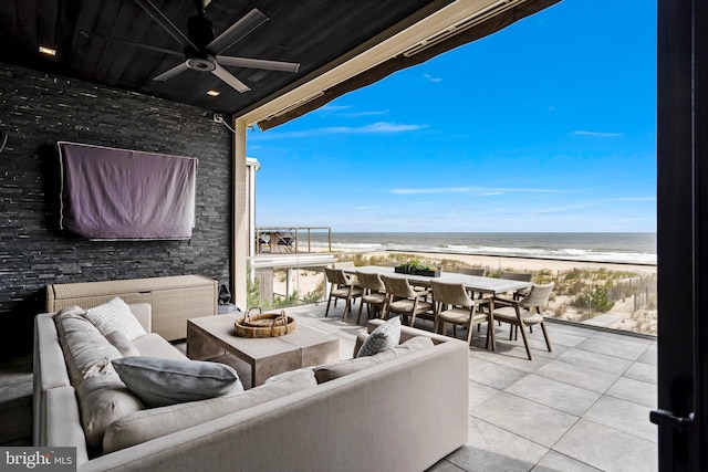 view of patio featuring an outdoor living space, a water view, a view of the beach, and ceiling fan