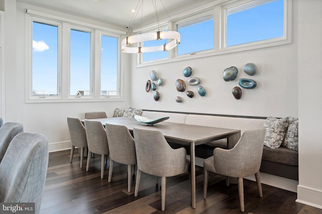 dining room with breakfast area, dark hardwood / wood-style floors, a wealth of natural light, and a notable chandelier