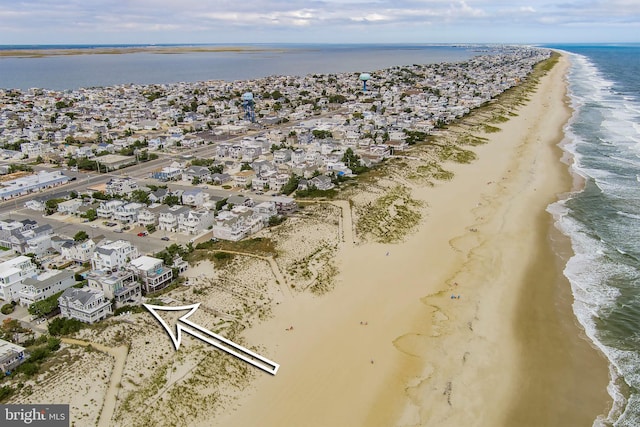 drone / aerial view with a water view and a beach view