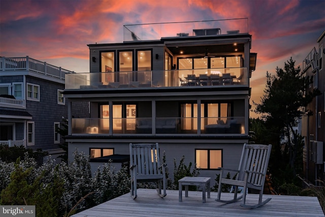 back house at dusk with a balcony