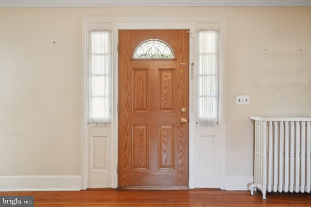 entrance foyer featuring radiator heating unit and hardwood / wood-style flooring