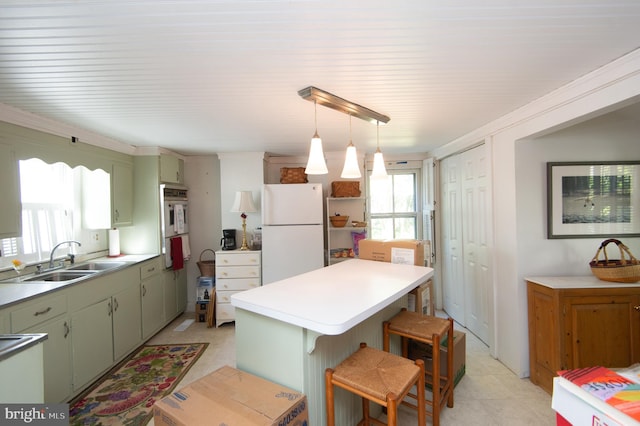 kitchen featuring a kitchen island, a kitchen bar, sink, green cabinetry, and white appliances