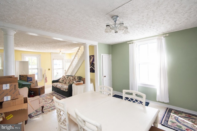 dining room with a textured ceiling and decorative columns