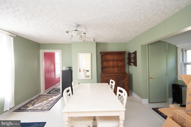 dining area featuring a textured ceiling and a chandelier