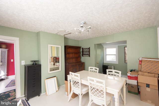 dining space featuring a textured ceiling, a chandelier, and radiator