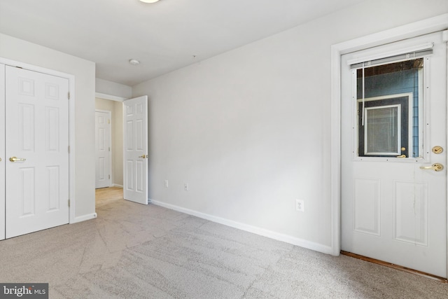 unfurnished bedroom featuring light carpet