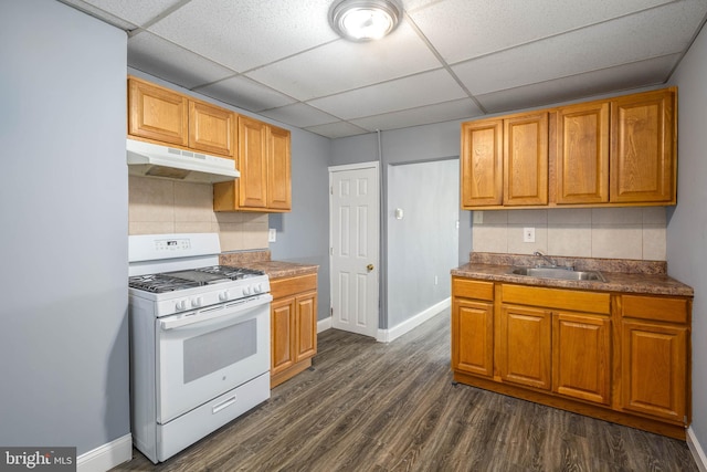 kitchen featuring sink, tasteful backsplash, a drop ceiling, dark hardwood / wood-style floors, and white gas stove